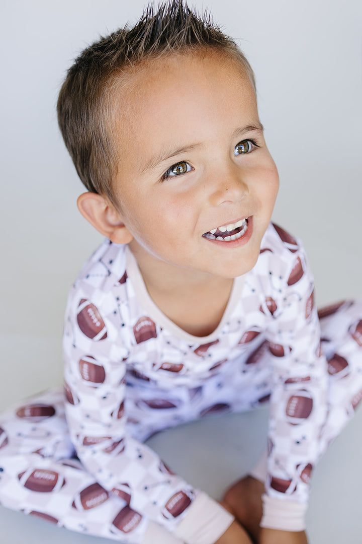 Child wearing pajamas with a pattern of american football 