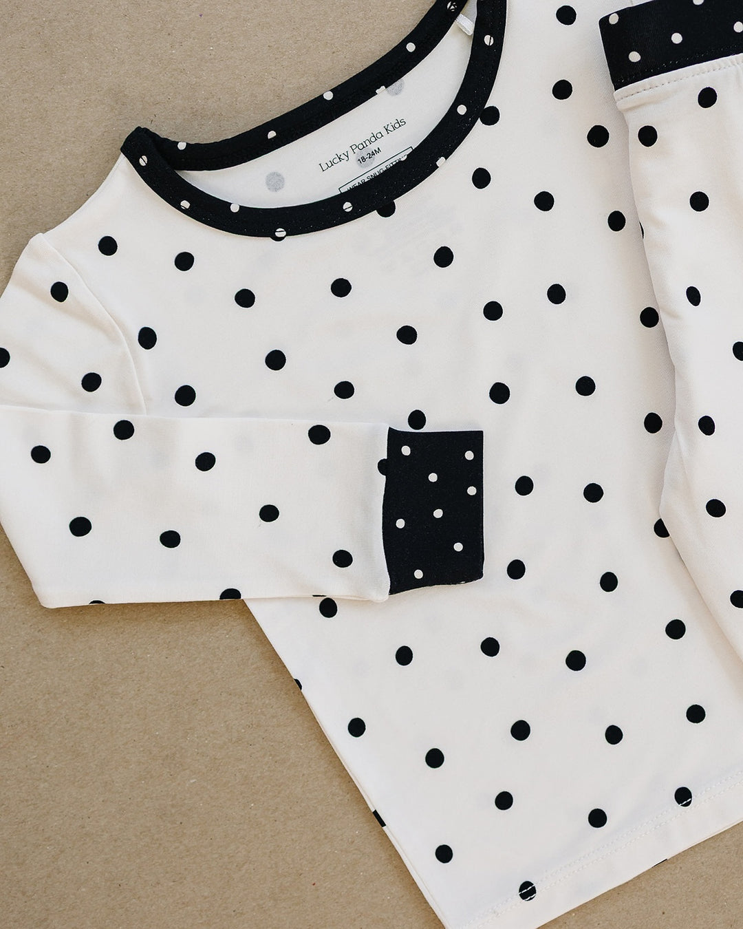Close up of the Classic Polka Bamboo top with black neckline and pocket detail