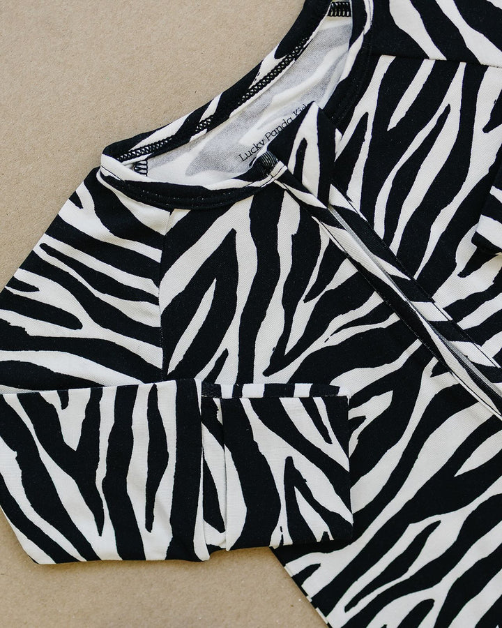 Close up of the Zebra Bamboo Zip Romper showing the neckline and print