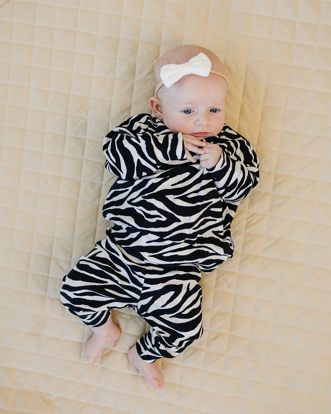 Baby relaxing in the Zebra Jogger Set with black and white animal print