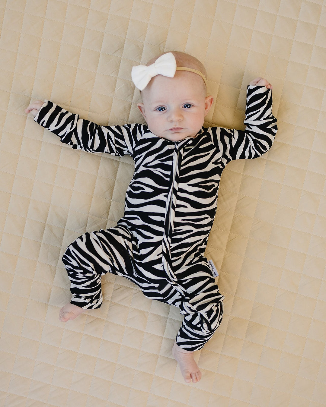 Baby wearing the Zebra Bamboo Zip Romper with bold black and white animal print