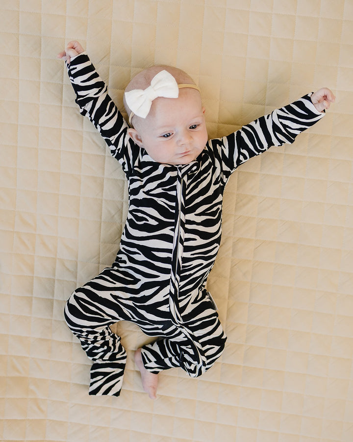 Baby wearing the Zebra Bamboo Zip Romper with arms raised