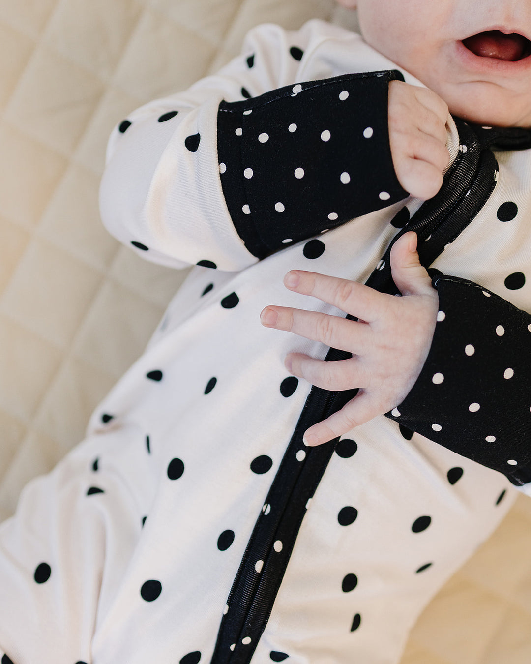 Close up of the Classic Polka Bamboo Zip Romper showing the zipper and black cuff