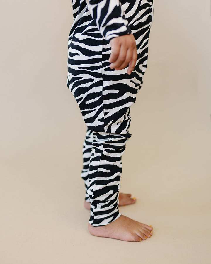 Close up of the Zebra Bamboo Zip Romper showing the leg fit and animal print