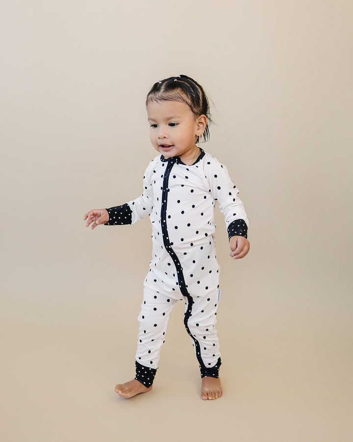 Little one standing in the Classic Polka Bamboo Zip Romper