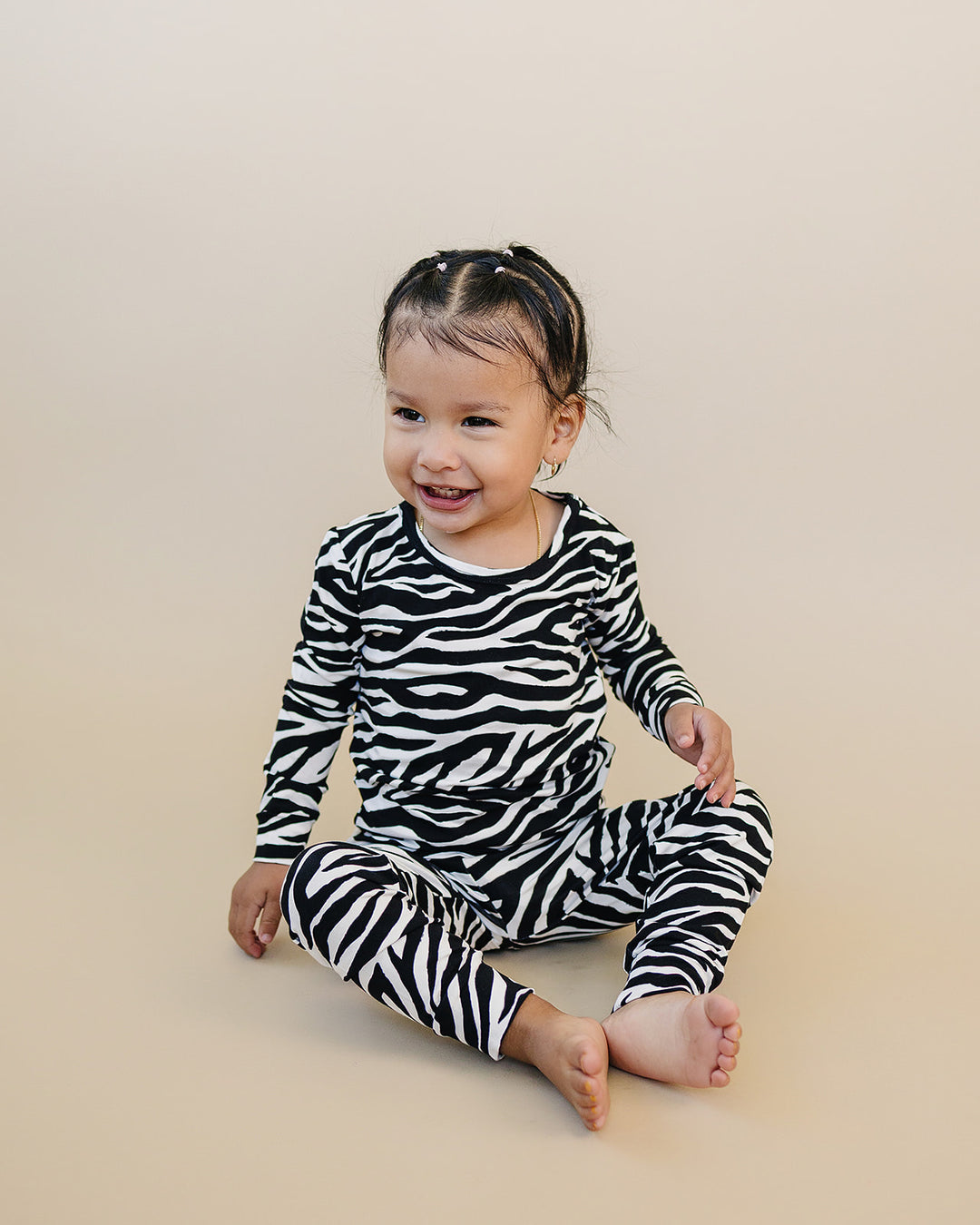 Seated little one wearing the Zebra Bamboo Two Piece Set
