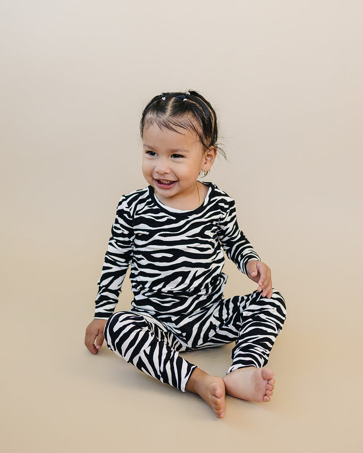 Seated little one wearing the Zebra Bamboo Two Piece Set