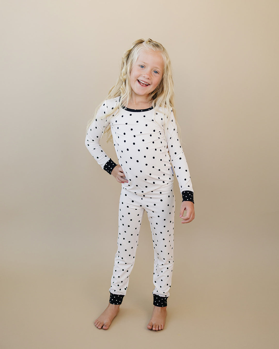 Little one wearing the Classic Polka Bamboo Two Piece Set in a black polka dot print on white