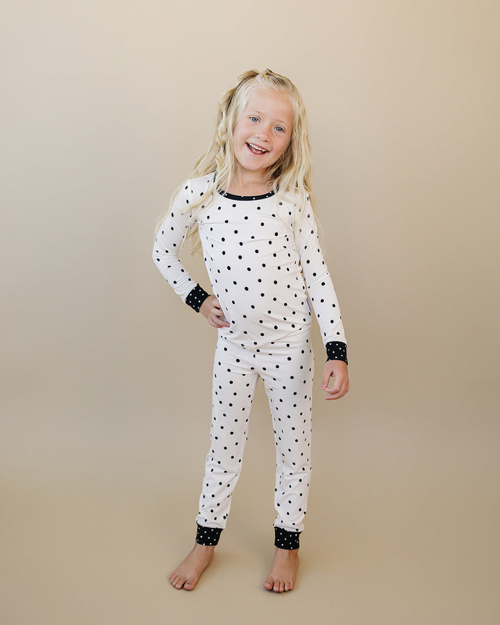 Little one wearing the Classic Polka Bamboo Two Piece Set in a black polka dot print on white
