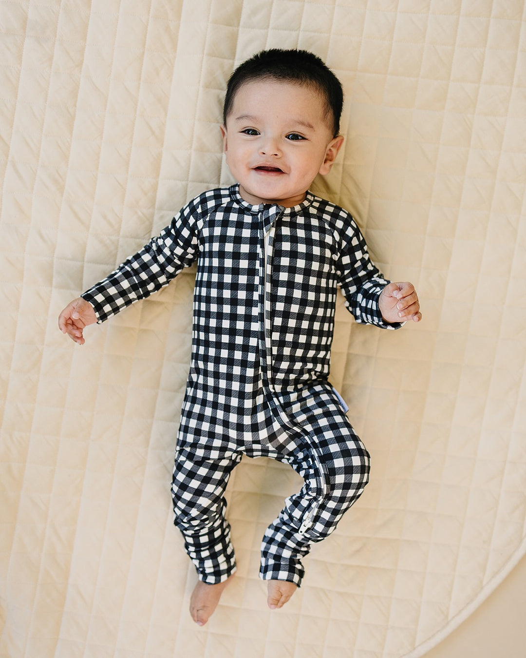 Baby wearing the Black Gingham Bamboo Zip Romper in a black and white check print