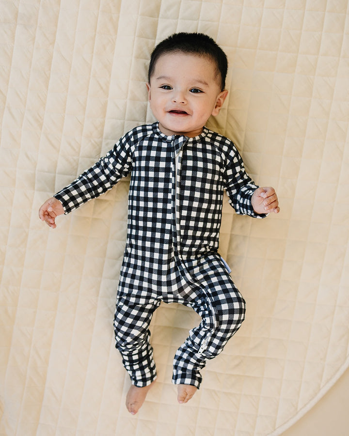 Baby wearing the Black Gingham Bamboo Zip Romper in a black and white check print