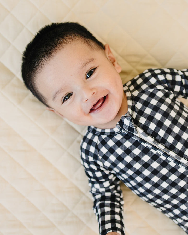 Close up of baby wearing the Black Gingham Bamboo Zip Romper