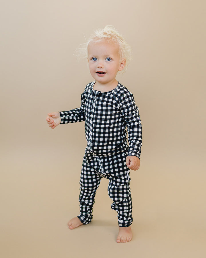 Full length view of little one wearing the Black Gingham Bamboo Zip Romper