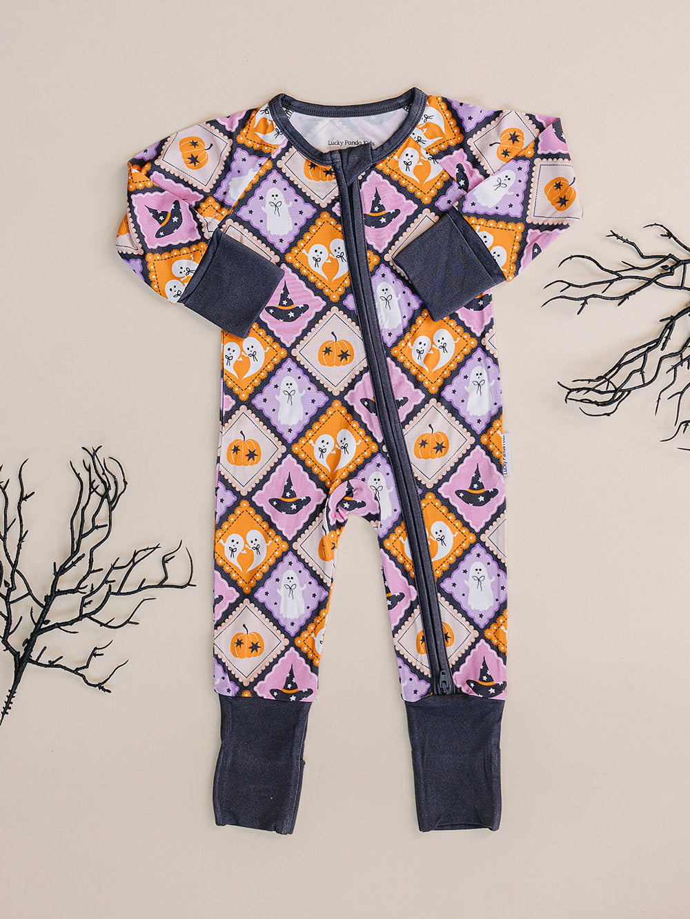 Ghost Whimsy Halloween Bamboo Zip Romper displayed flat with dried branch decor.