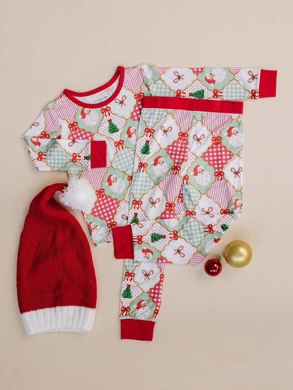 Santa Patchwork Bamboo Two Piece — toddler girl in ornament patchwork Christmas pajama set, Lucky Panda Kids, flat lay
