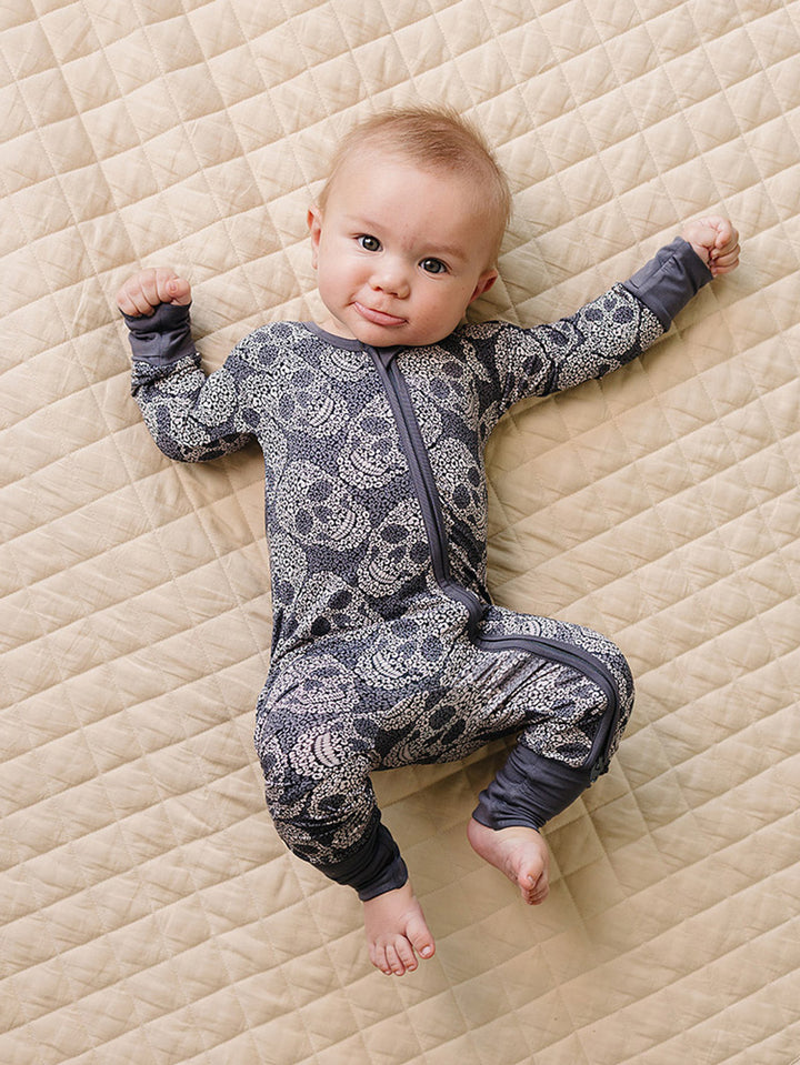 Full-length view of a baby wearing the grey Leopard Skull Bamboo Zip Romper.