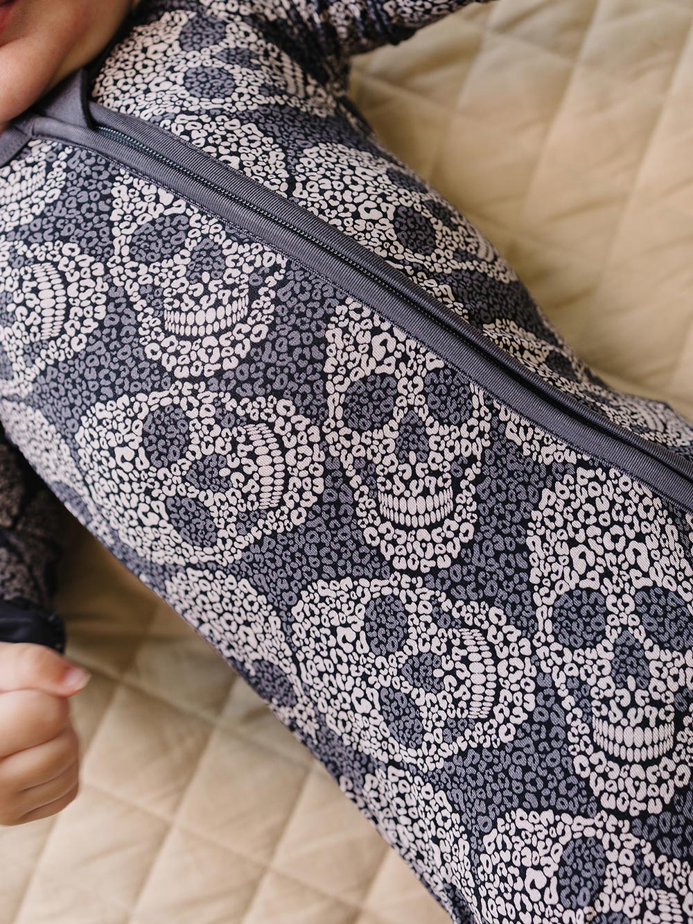 Close-up of the zipper and grey leopard skull print on the bamboo romper.