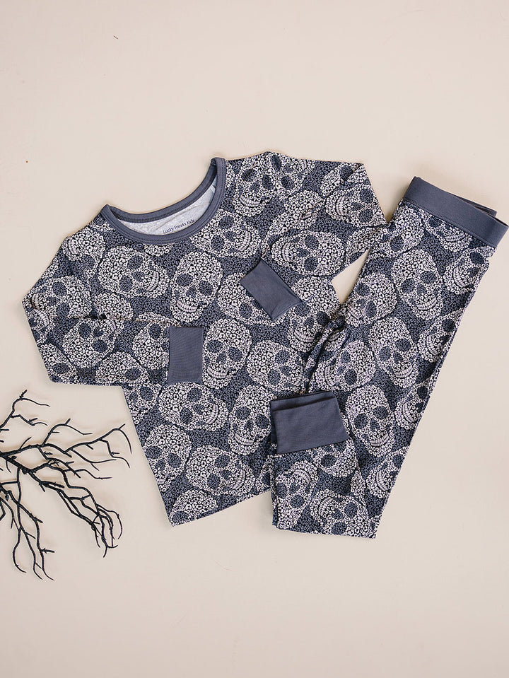 Leopard Skull Halloween Bamboo Pajama Set displayed flat with dried branch decor.
