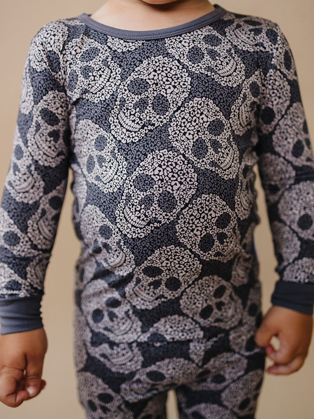 Close-up of a child wearing the grey Leopard Skull Halloween bamboo pajama top.