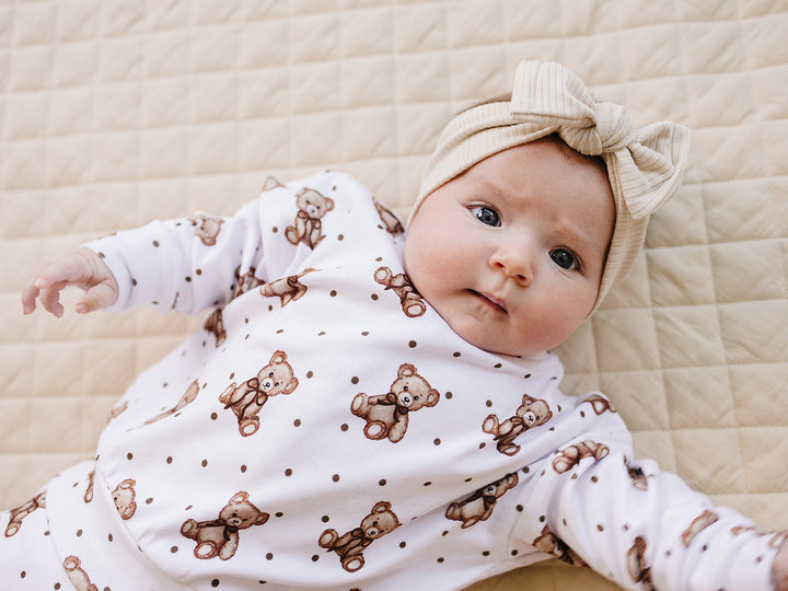 Baby lying sideways in the Cute Bear long-sleeve top and matching jogger pants.

