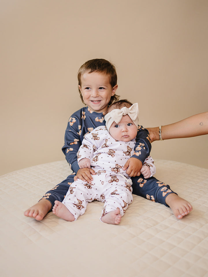Child wearing the Bear Vibes jogger set while sitting with a baby in a coordinating bear-print outfit.