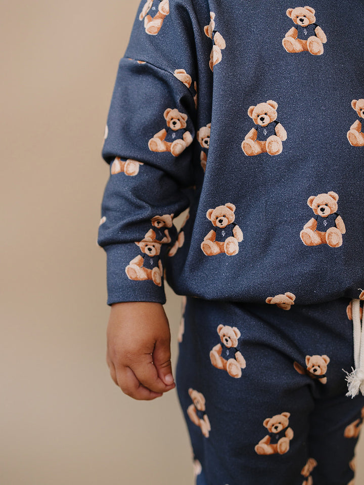 Close-up of the teddy bear print, crewneck top, and matching jogger pants.