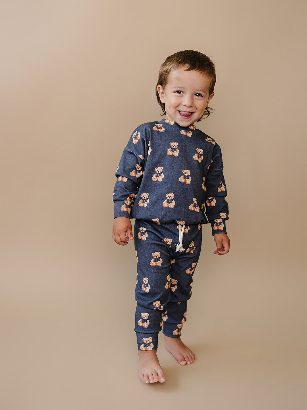 Child modeling the dark charcoal Bear Vibes jogger set with an all-over teddy bear print.