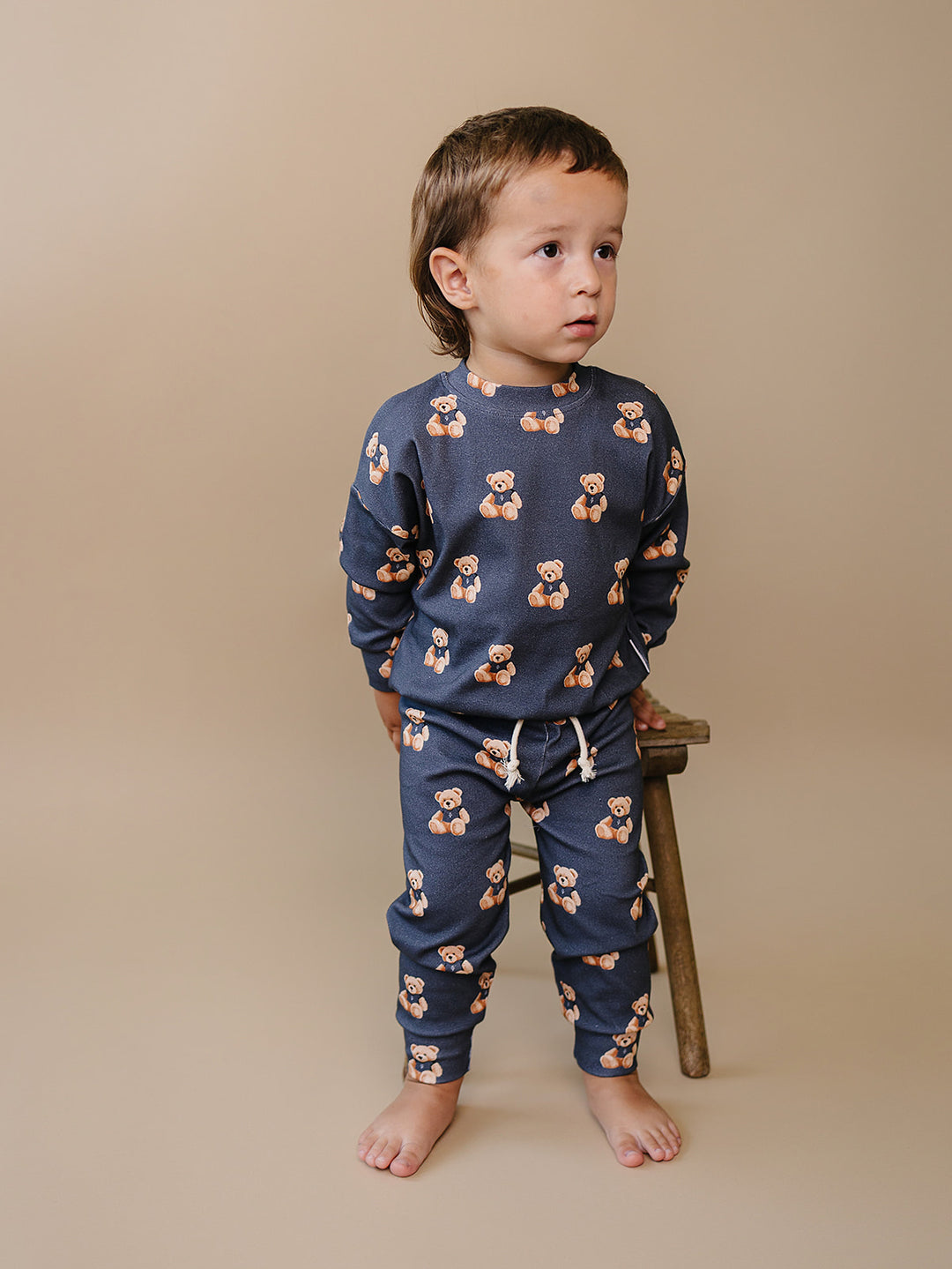 Side view of a toddler modeling the Bear Vibes long-sleeve top and jogger pants.