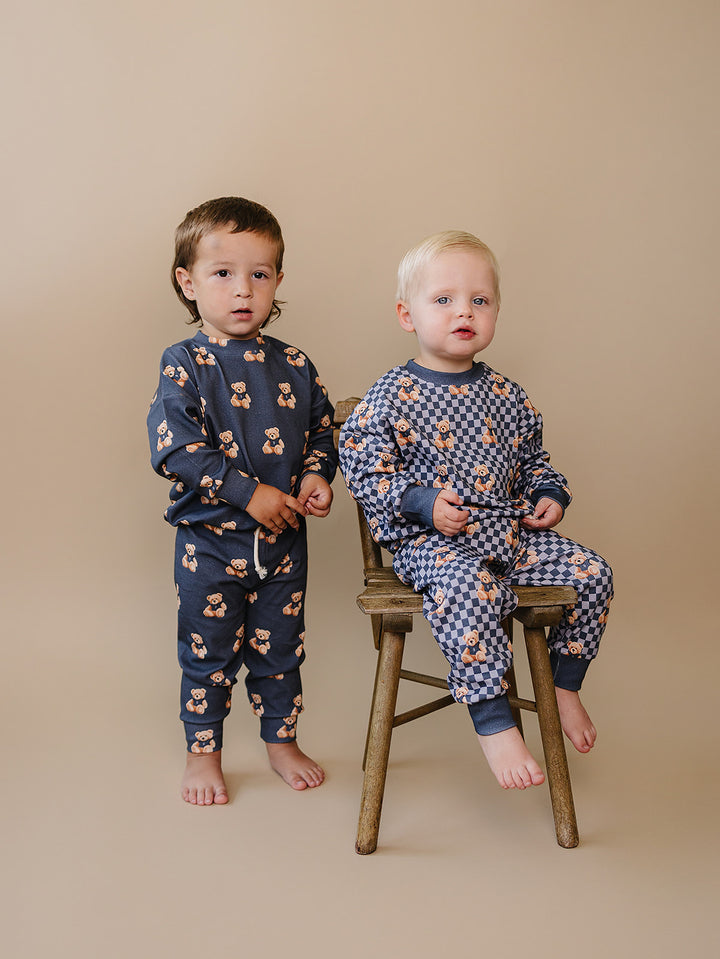 Baby and older child wearing coordinating Checkered Bear Vibes outfits.