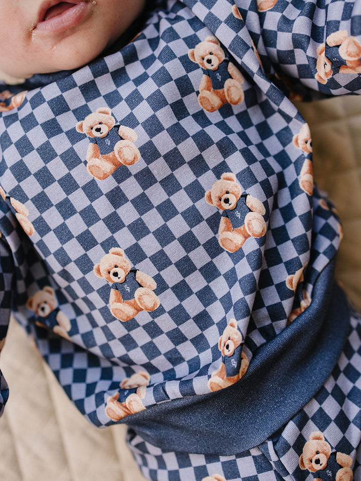 Close-up of the blue checkered pattern and playful bear print on the cotton jogger set.