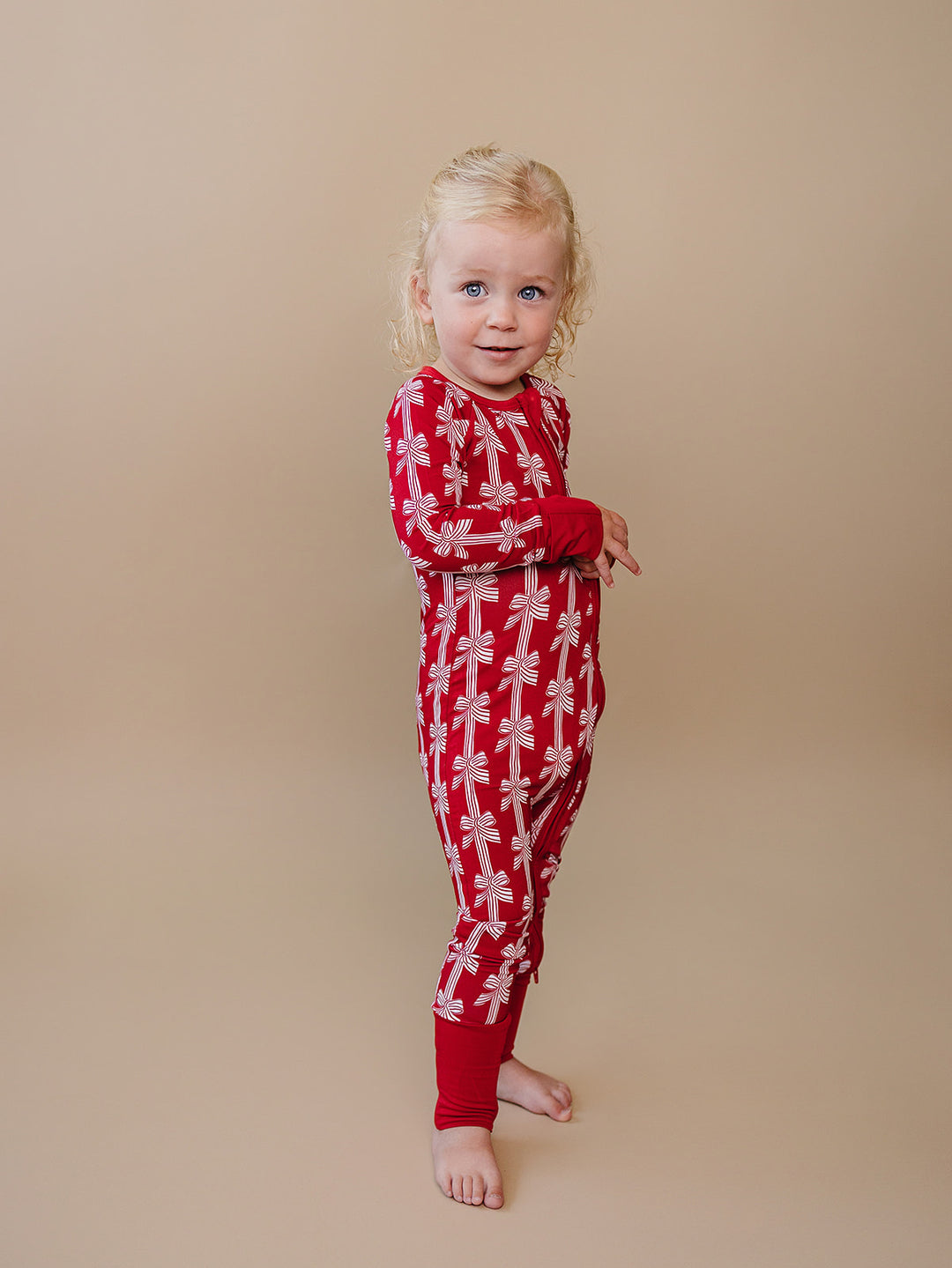 Red Bows Bamboo Zippy — baby girl in red bow-print Christmas romper, Lucky Panda Kids