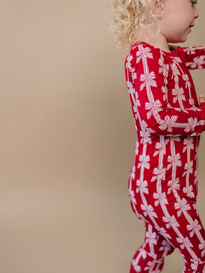Red Bows Bamboo Zippy — baby girl in red bow-print Christmas romper, Lucky Panda Kids