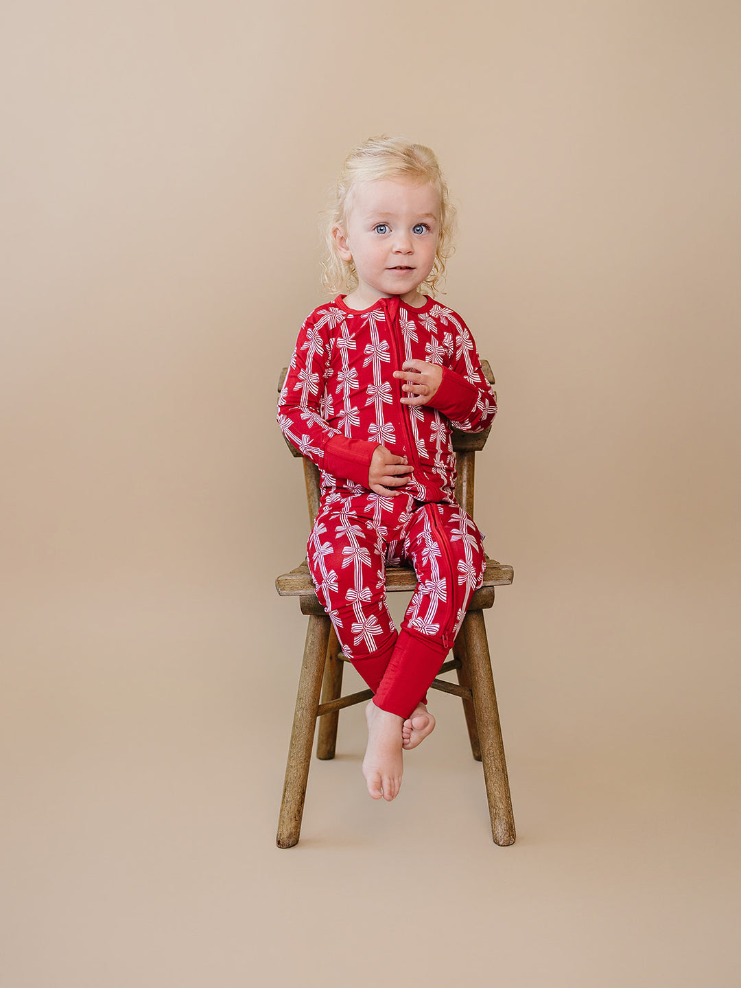 Red Bows Bamboo Zippy — baby girl in red bow-print Christmas romper, Lucky Panda Kids