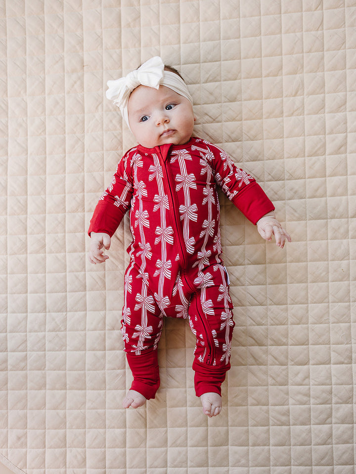 Red Bows Bamboo Zippy — baby girl in red bow-print Christmas romper, Lucky Panda Kids