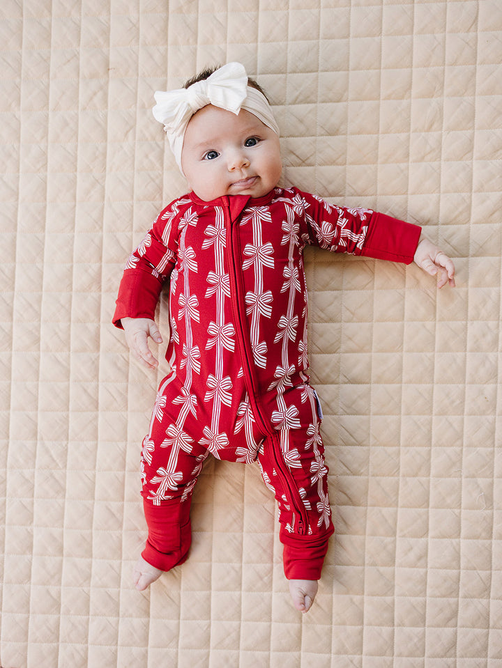 Red Bows Bamboo Zippy — baby girl in red bow-print Christmas romper, Lucky Panda Kids