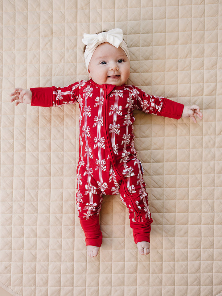 Red Bows Bamboo Zippy — baby girl in red bow-print Christmas romper, Lucky Panda Kids