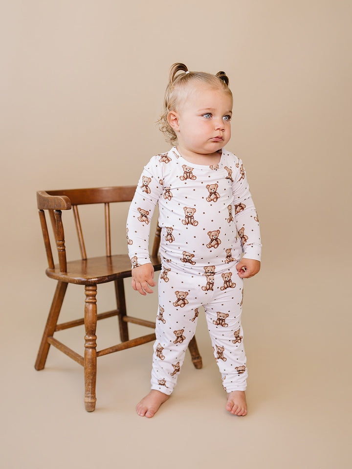 Full-length front view of a toddler wearing the white teddy bear-print bamboo set.