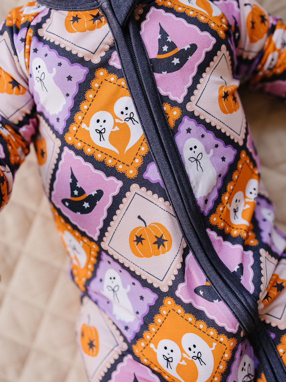 Close-up of the zipper and colorful ghost, pumpkin, and witch-hat print.