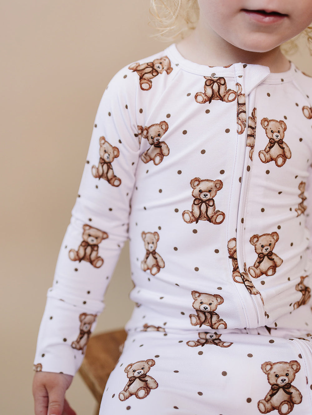 Close-up of the two-way zipper and teddy bear print on the bamboo romper.