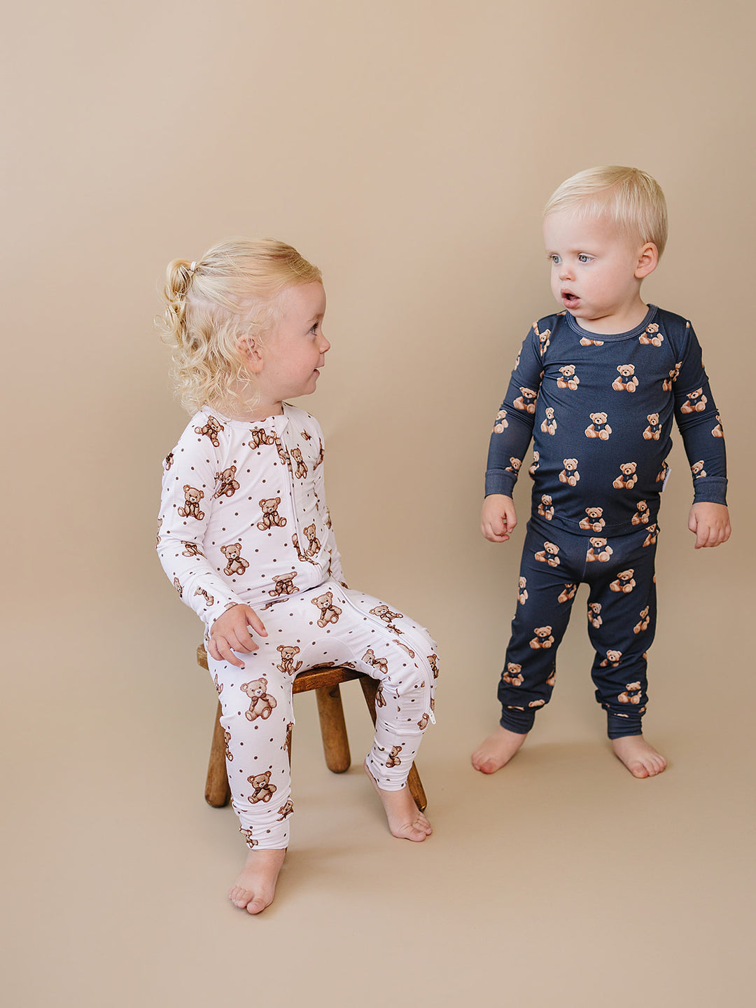 Two toddlers wearing coordinating dark charcoal and Cute Bear Vibes bamboo outfits.