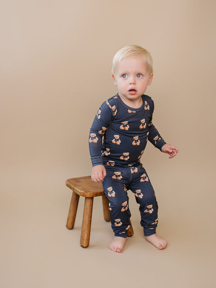 Toddler modeling the dark charcoal teddy bear-print bamboo set against a neutral background.