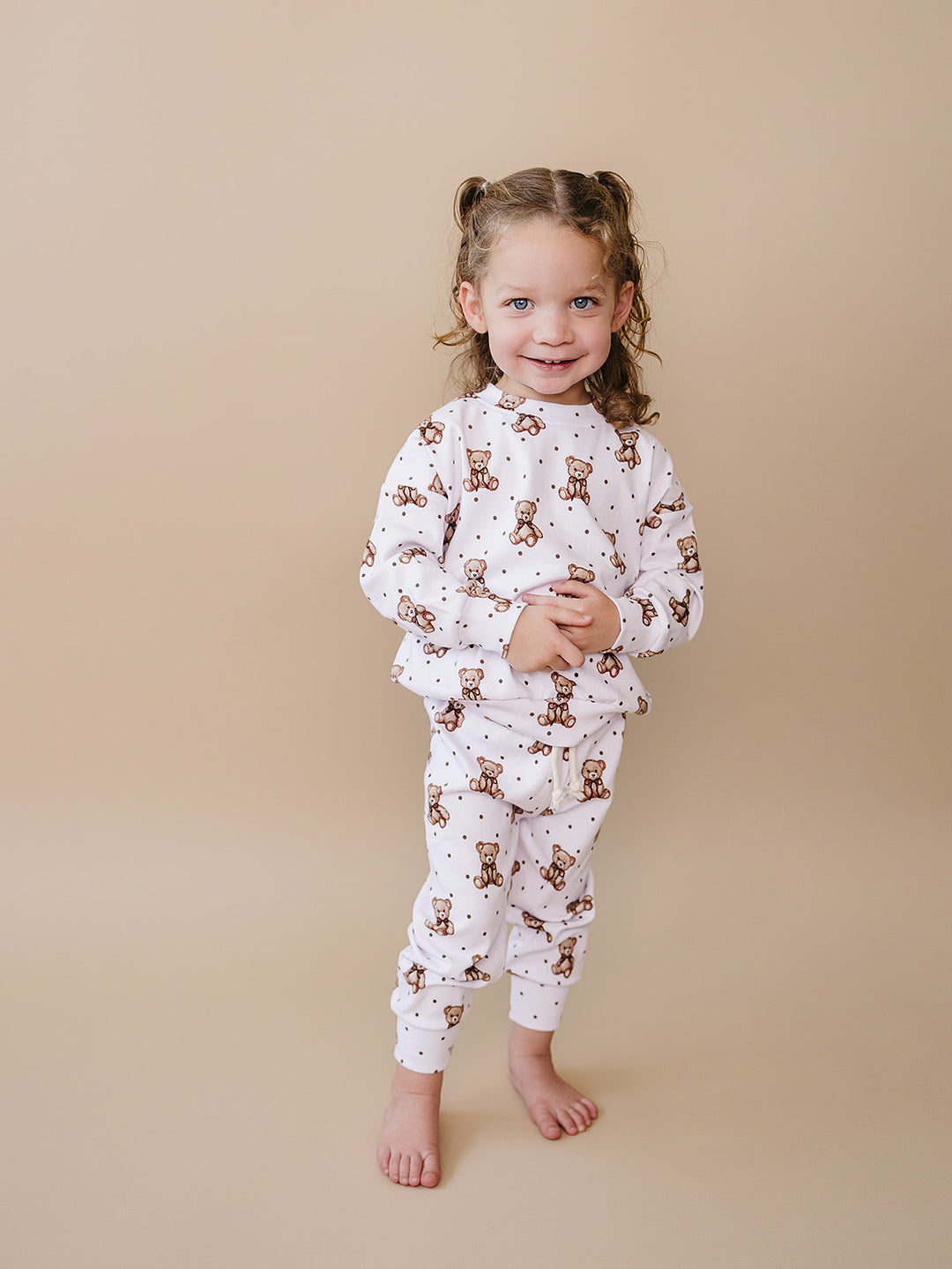 Smiling toddler wearing the Cute Bear long-sleeve top and matching pants.
