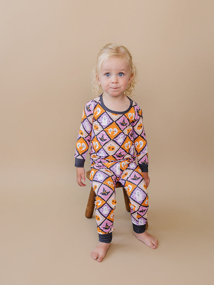 Front view of a toddler modeling the Ghost Whimsy bamboo pajama top and pants.