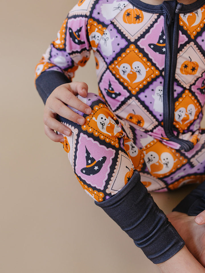 Close-up of an adult holding a baby wearing the Ghost Whimsy Bamboo Zip Romper.