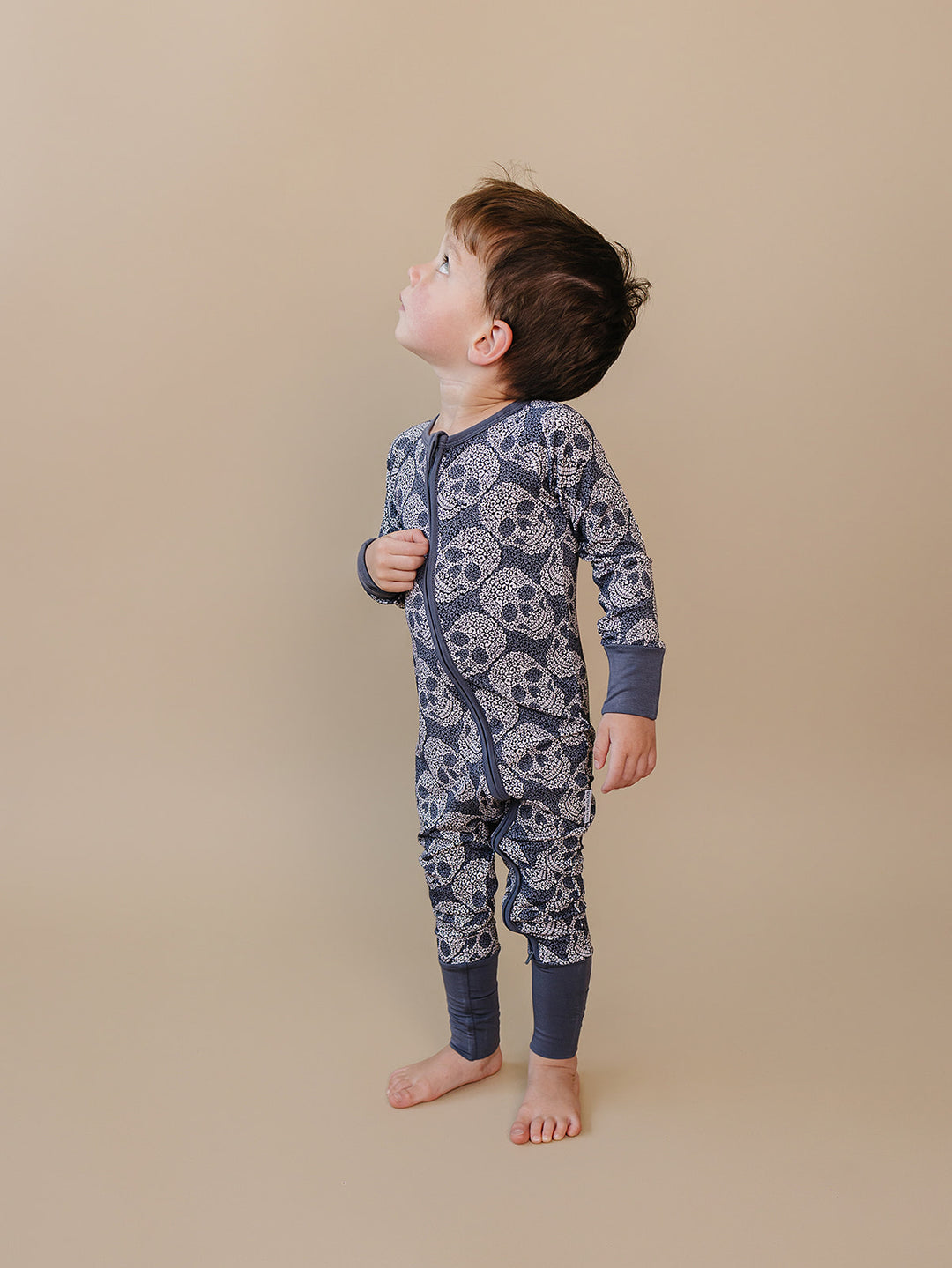 Side view of a toddler wearing the grey Leopard Skull Bamboo Zip Romper.