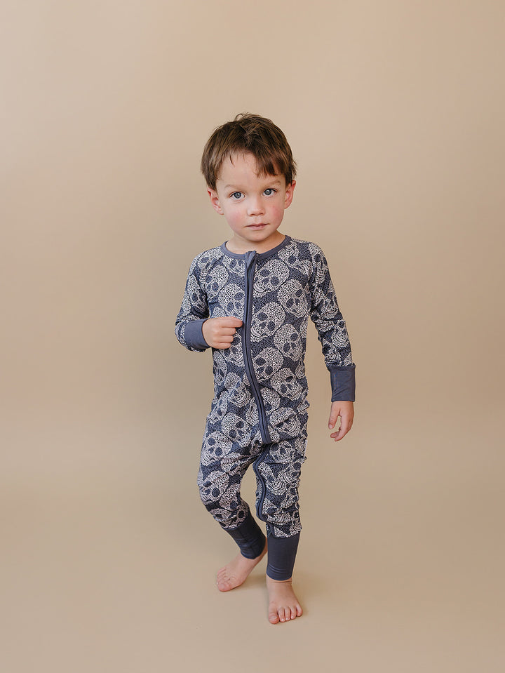Front view of a toddler modeling the Leopard Skull Bamboo Zip Romper.