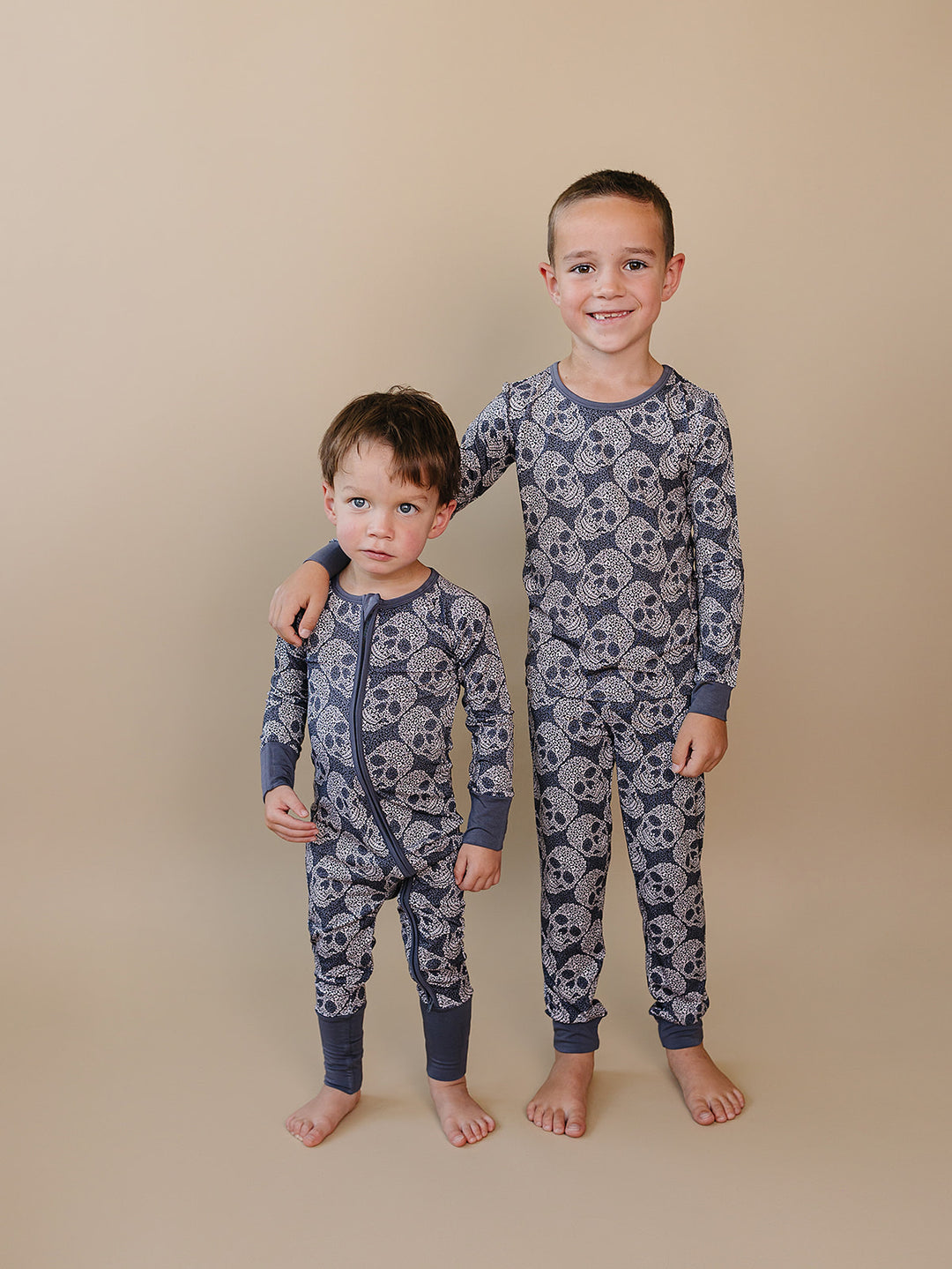 Two boys wearing matching grey Leopard Skull Halloween bamboo pajama sets.