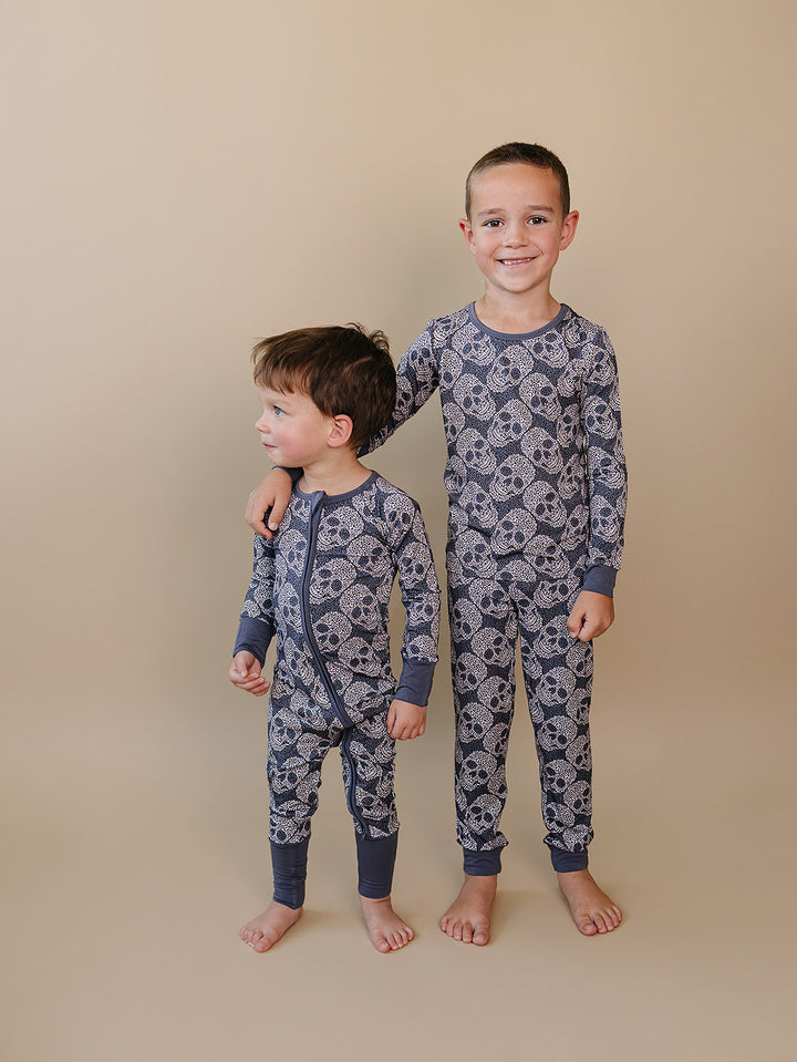 Two boys standing together in matching Leopard Skull Halloween bamboo pajamas.