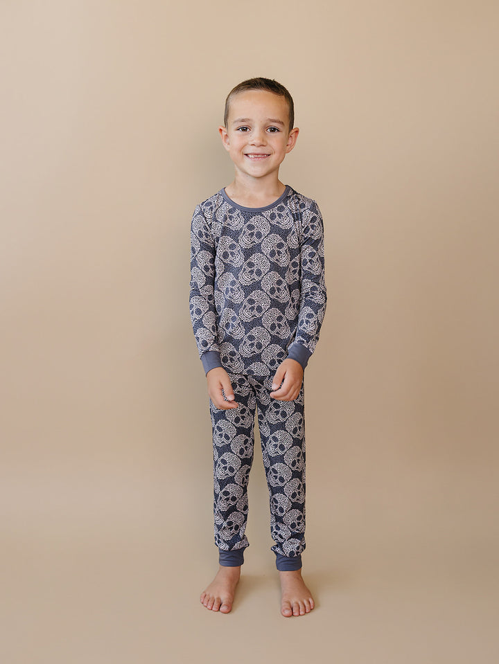 Front view of a child wearing the grey Leopard Skull Bamboo Pajama Set.