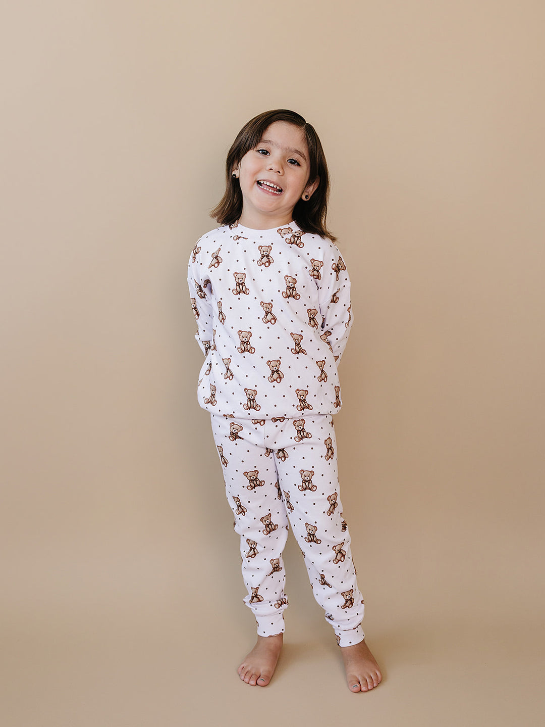 Full-length front view of a child wearing the teddy bear-print top and matching joggers.
